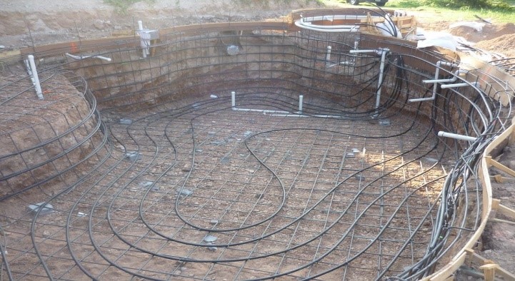 Laying geothermal loops during pool construction